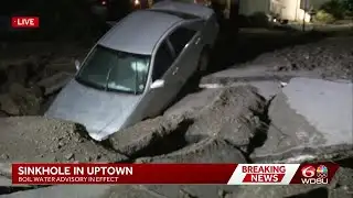 Car stuck in massive sinkhole in Uptown