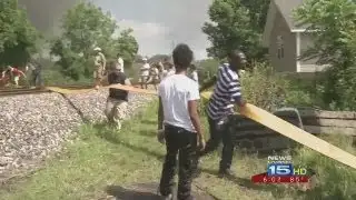 Community members help firefighters with hose