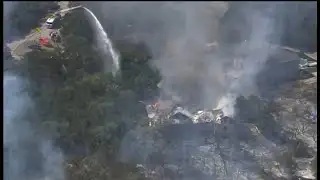Crews working to extinguish large grass fire that spread to North Side home