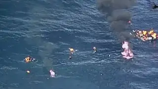 Dramatic moment desperate migrants jump from burning dinghy