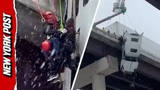 Driver rescued after crashed truck left hanging over bridge