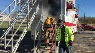 Firefighter hopefuls practice extinguishing a trailer fire