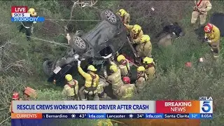 Rescue crews work to free driver after crash off Mulholland Drive
