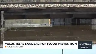 Volunteers sandbag for flood prevention
